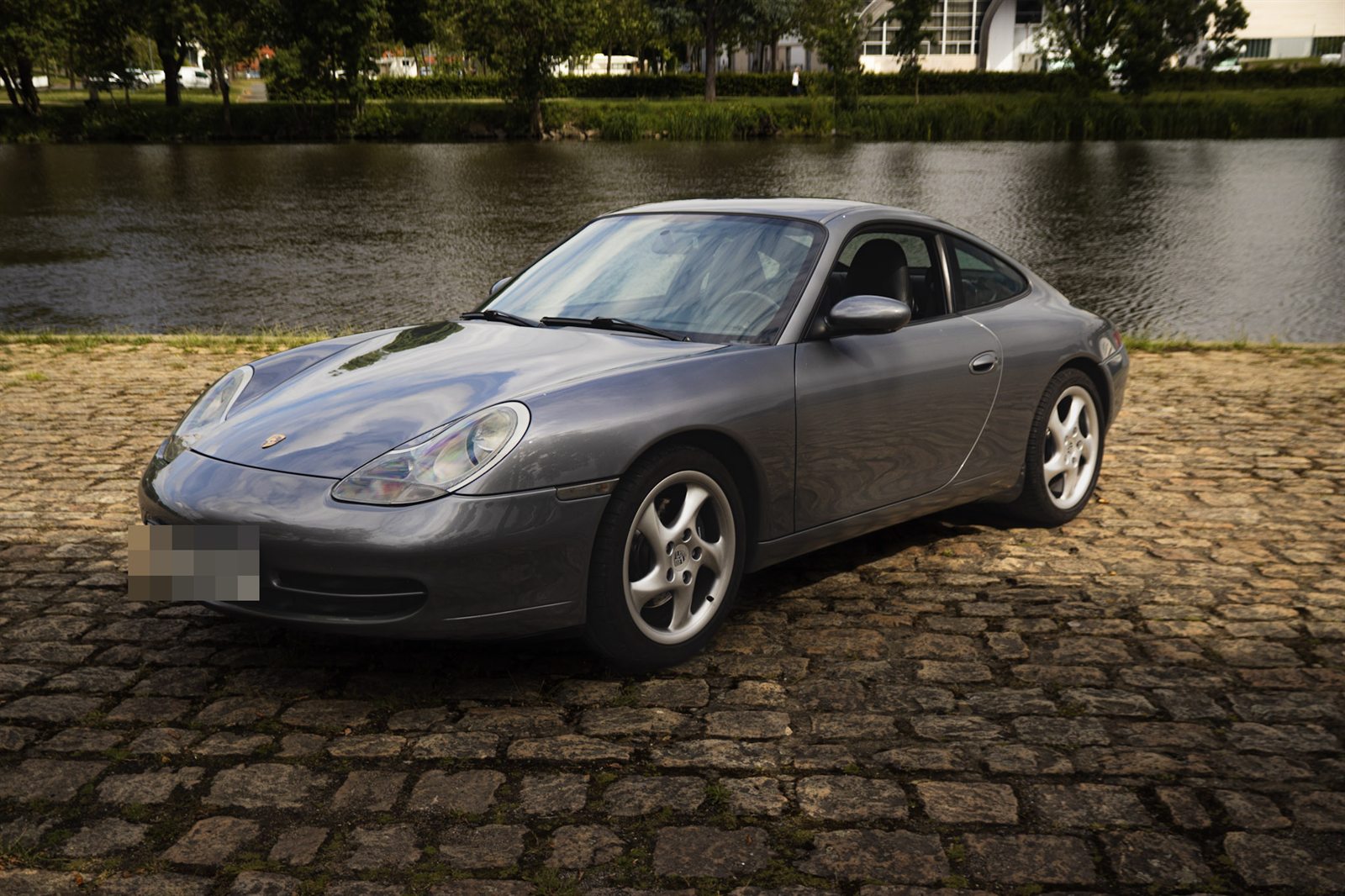 La voiture de sport gris métallisé de trois quarts avant, garée sur des pavés au bord de la Maine à Angers.